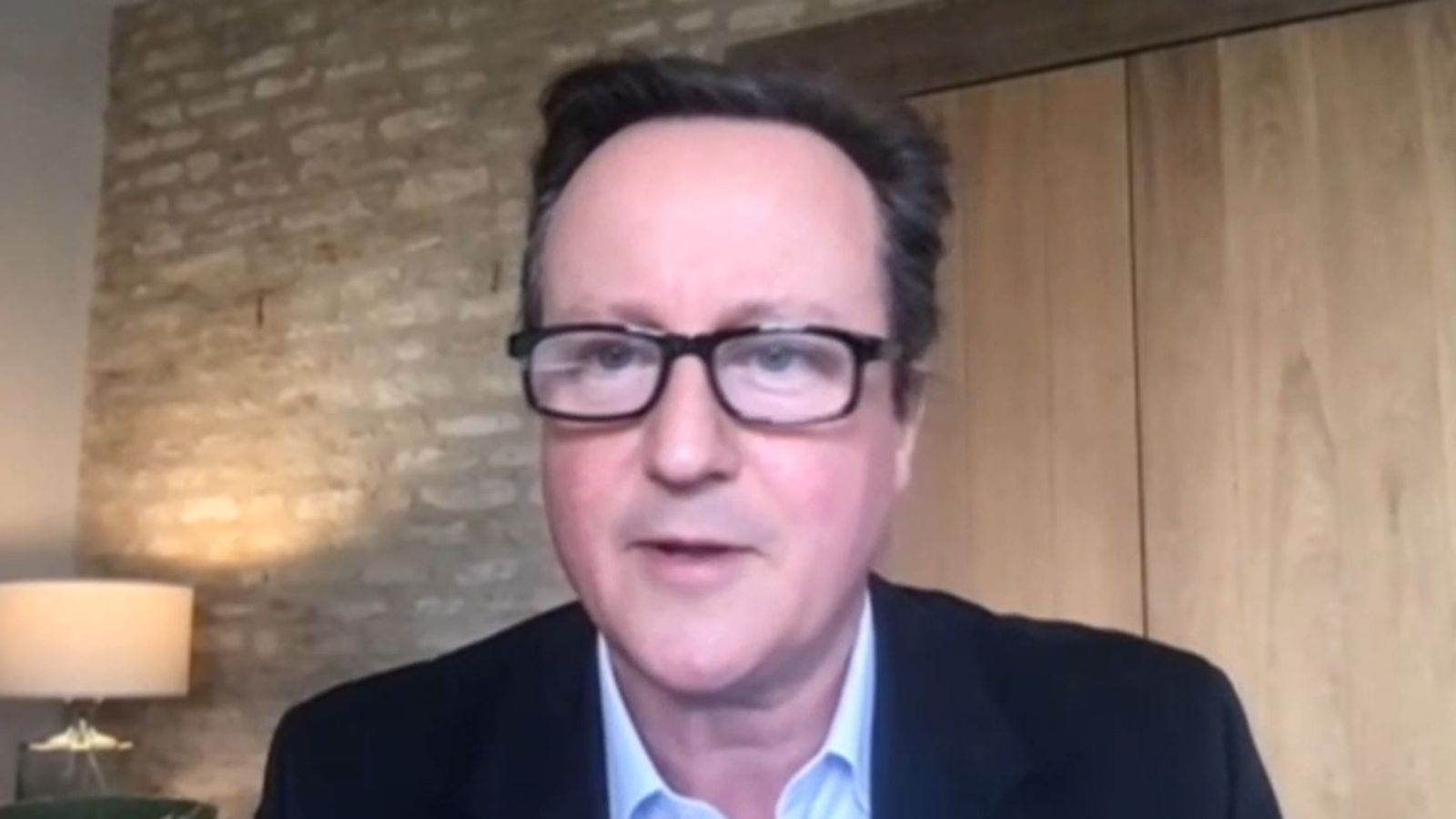 戴维·卡梅伦(David Cameron)穿着西装和领带对着镜头微笑:卡梅伦先生正在与国家安全战略委员会成员讲话